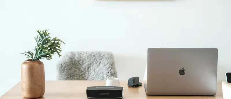 Aufgeräumter Arbeitsplatz mit MacBook auf einem Holztisch