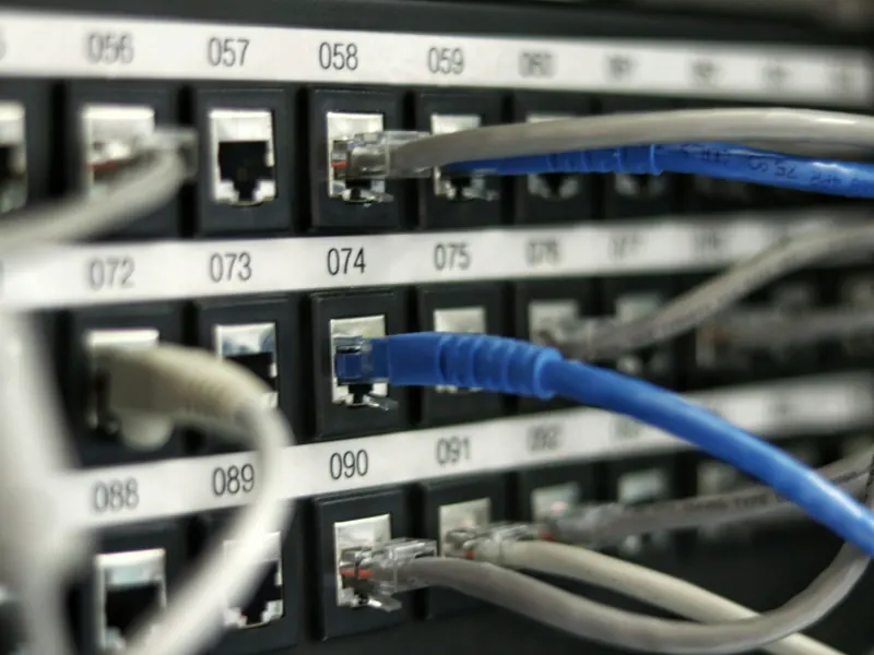 Patchpanel mit angeschlossenen blauen und grauen Netzwerkkabeln